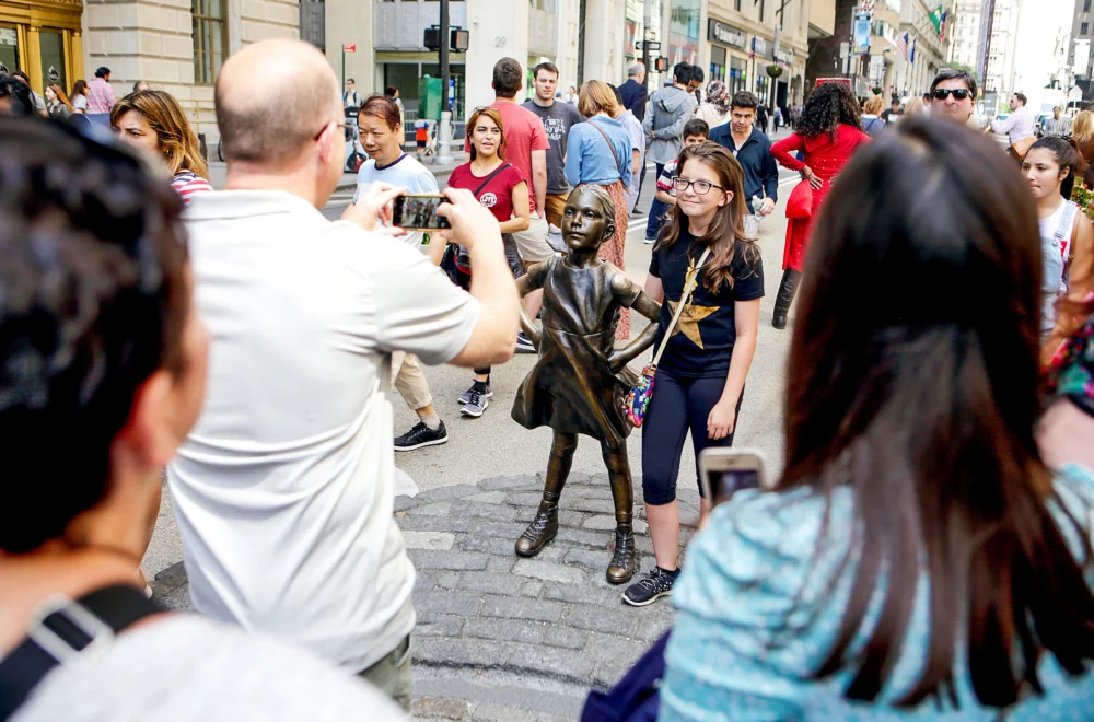 Travelers taking photos with the Fearless Girl Statue in NYC