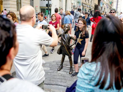 Travelers taking photos with the Fearless Girl Statue in NYC