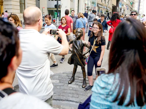 Travelers taking photos with the Fearless Girl Statue in NYC