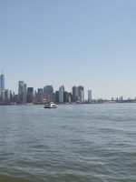 Young man looking at New York City skyline from Statue of Liberty cruise