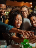 Dinner guests taking selfie at dinner table in NYC