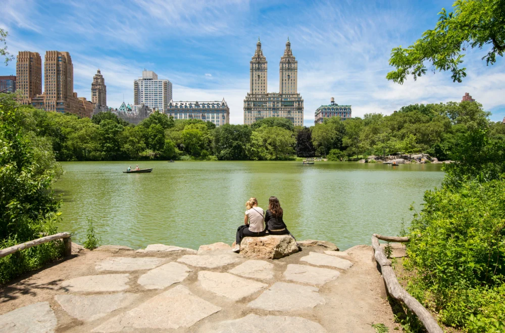 Two people sitting near the lake in Central Park during private NYC guided tour