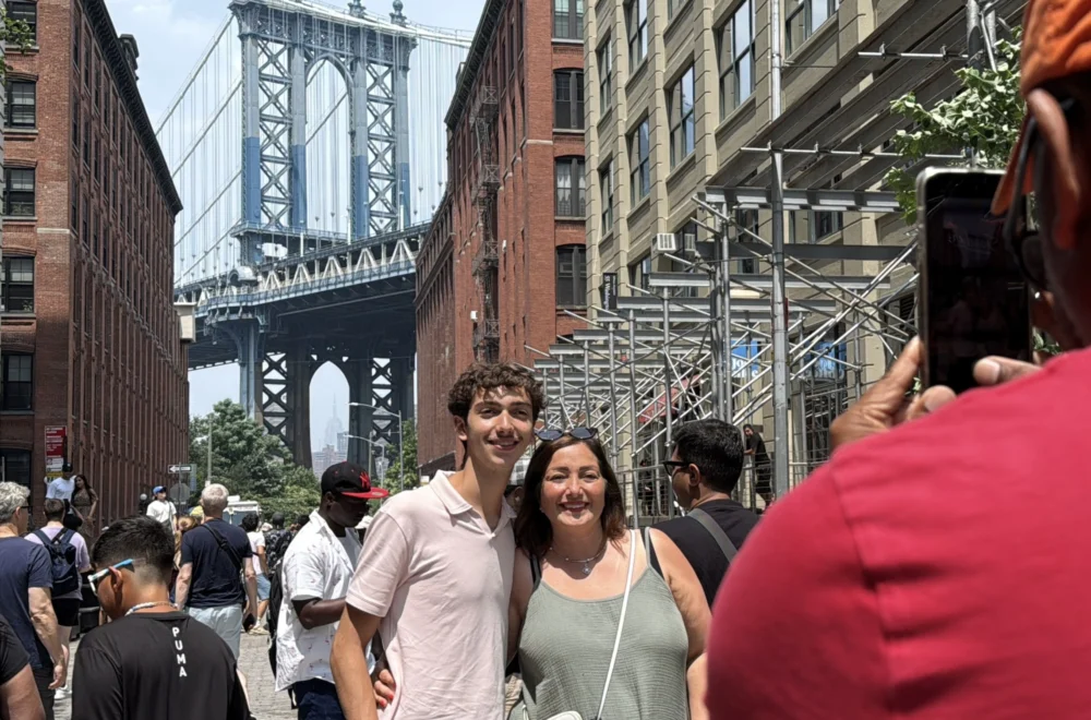 Two people taking a photo with Brooklyn Bridge during Beyond Manhattan private guided tour