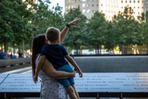 Mother holding child at Ground Zero memorial during VIP Insider tour