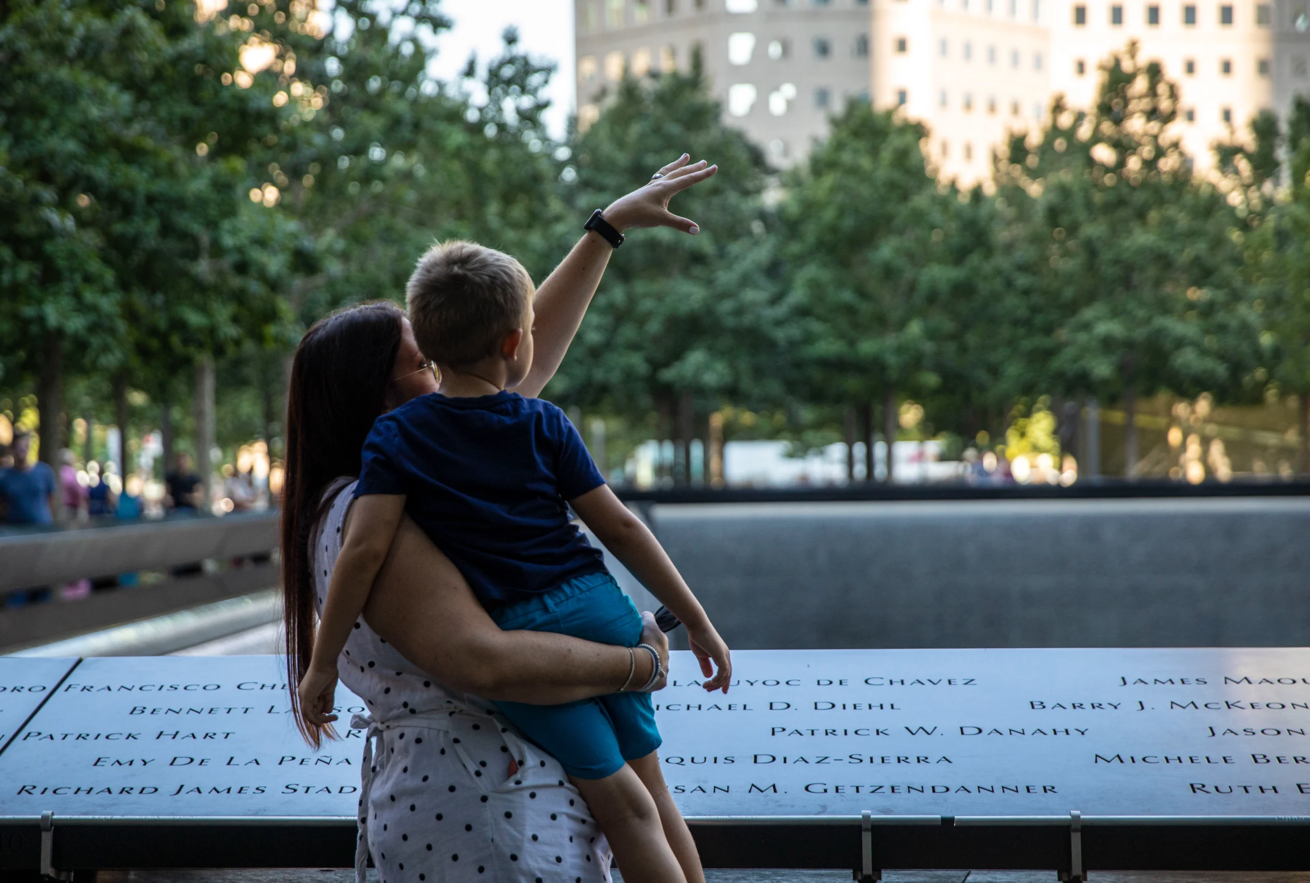 Mother holding child at Ground Zero memorial during VIP Insider tour