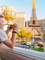 A young man photographs a panorama of the city with the alleys of Las Vegas