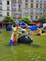 Whimsical modern fountain with bold sculptures in a public square in Le Marais, Paris.