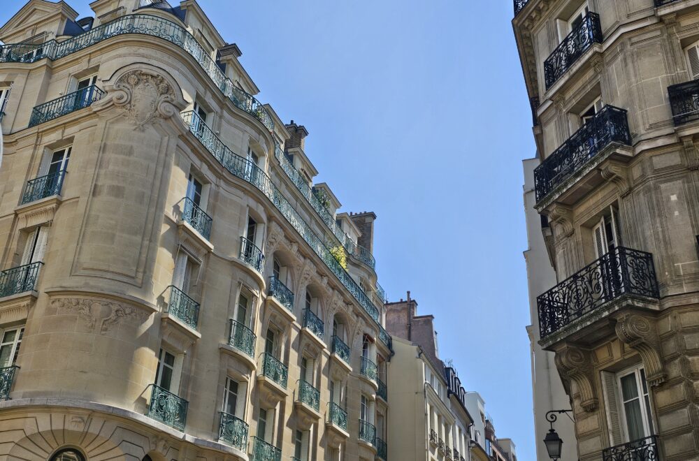 Elegant Haussmann-style architecture on a corner street in Le Marais, Paris.