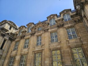Close-up of a grand Parisian building facade with classic French windows in Le Marais guided tour