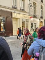 Group of tourists walking through a lively Parisian street during the Le Marais tour.