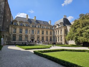 Peaceful garden courtyard at Place des Vosges with historic buildings in the background.