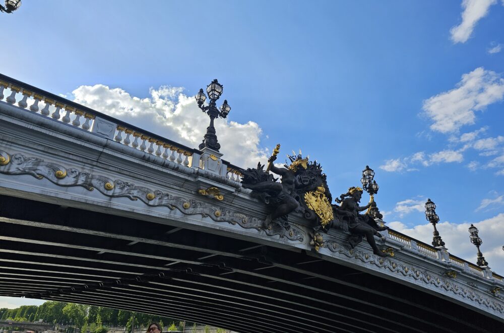 Bridge crossing the Seine River with sculptural detail and a bright sky during Le Marais guided tour