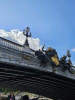 Bridge crossing the Seine River with sculptural detail and a bright sky during Le Marais guided tour