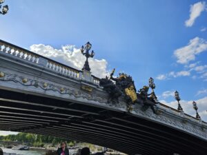 Bridge crossing the Seine River with sculptural detail and a bright sky during Le Marais guided tour