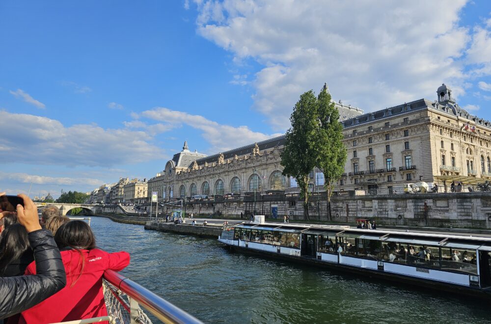 Scenic river view with boats cruising the Seine near Le Marais and the Île de la Cité.