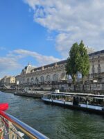 Scenic river view with boats cruising the Seine near Le Marais and the Île de la Cité.