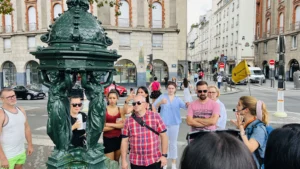 Guide and guests at Fontaine Wallace in Unofficial Emily in Paris tour
