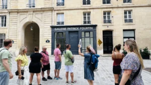 Guide explaining to the group during Unofficial Emily in Paris tour at Place de Valois