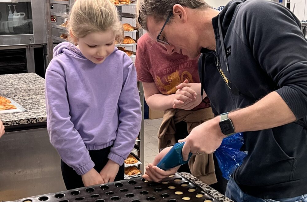 Father and daughter piping into tray