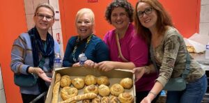 Guests posing with tray of freshly baked bread