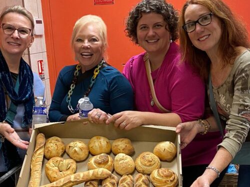 Guests posing with tray of freshly baked bread
