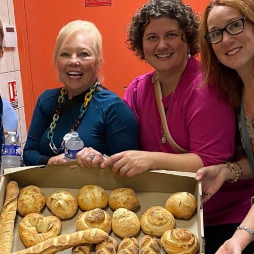 Guests posing with tray of freshly baked bread