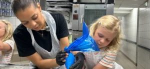Child piping macarons in French baking class