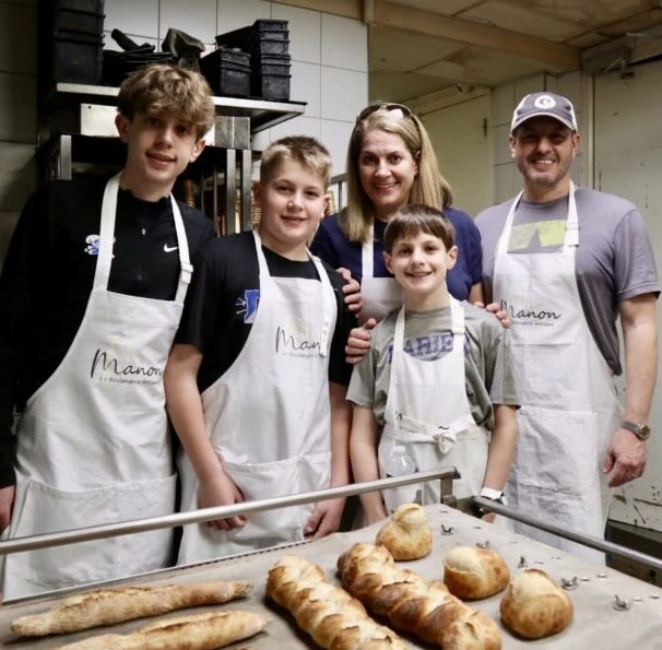 Family posing with tray of baked bread