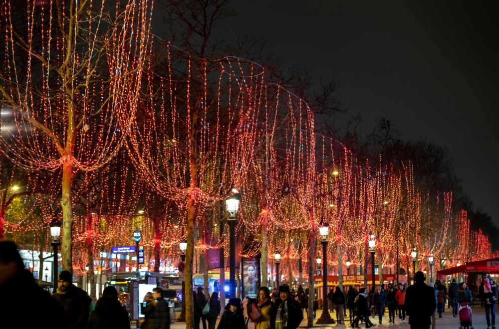People walking through Champs Elysees with holiday lights on Paris Christmas tour