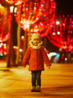 Preschooler girl on Champs Elysees with its traditional Christmas illumination in Paris, France