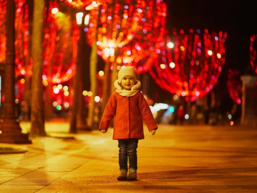 Preschooler girl on Champs Elysees with its traditional Christmas illumination in Paris, France