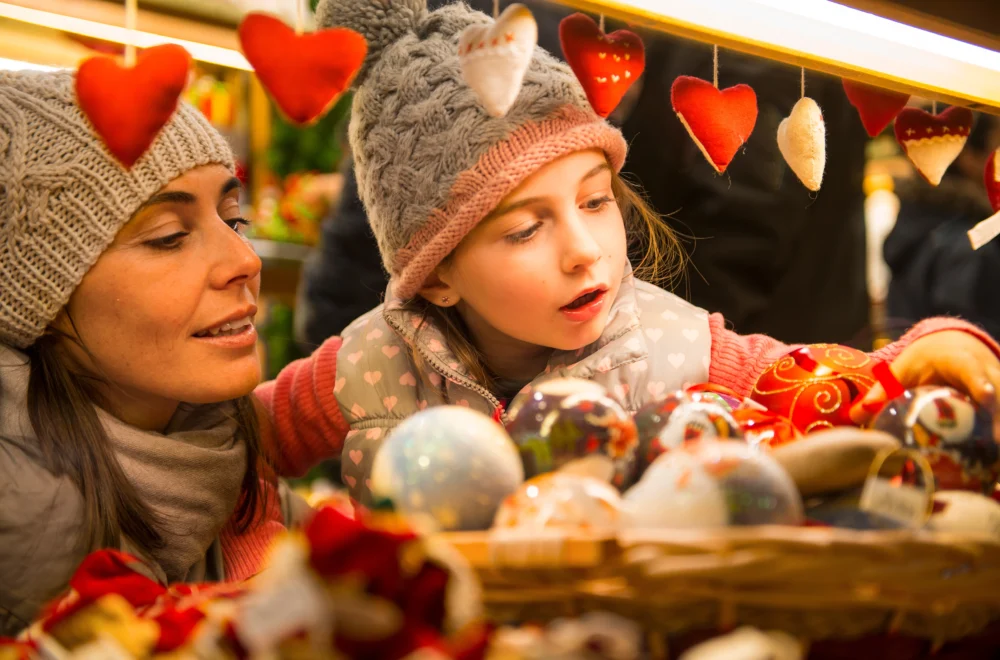 Mother and daughter looking at Christmas Market stall during private Christmas Lights guided tour