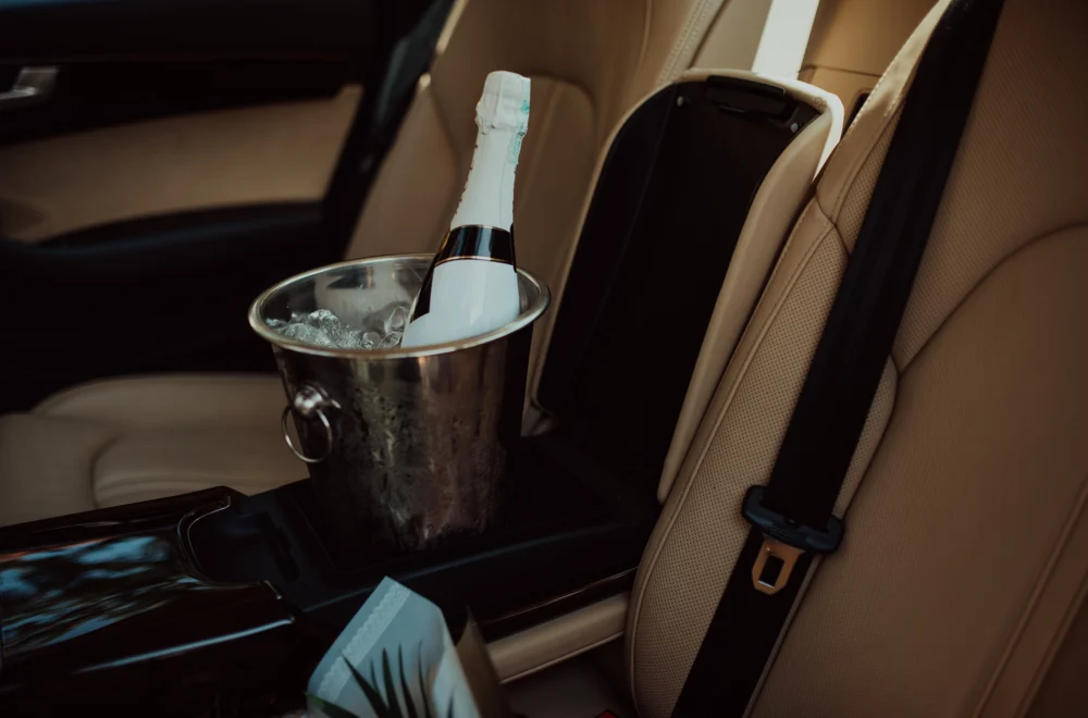 Bottle of champagne and glass in luxury car