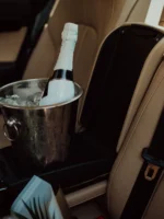 Bottle of champagne and glass in luxury car