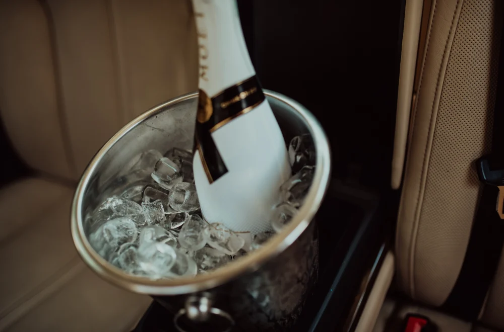 Bottle of champagne and glass in luxury car during private Los Angeles tour
