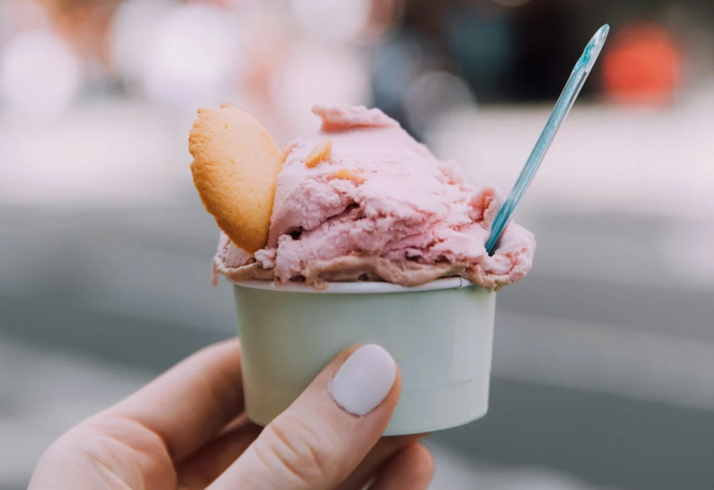 person holding ice cream cup with ice cream