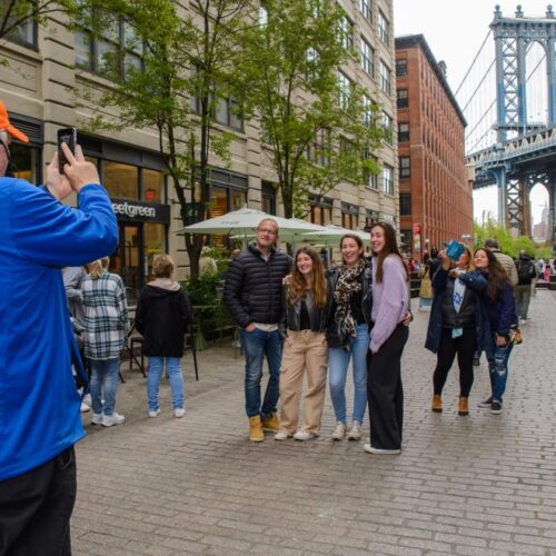 Tour-guide-taking-photo-of-guests-in-Brooklyn-Bronx-Queens-Bus-Tour-1000×660