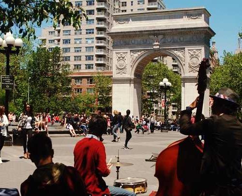 person holding contrabass near triump arch in greenwich village