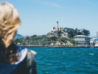 Woman looking at alcatraz island from on board the alcatraz cruise