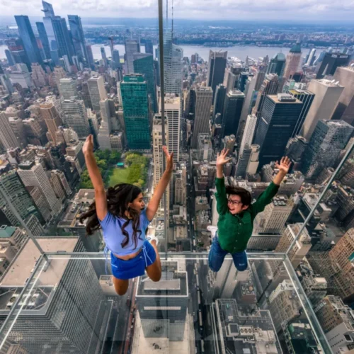Kids jump against the backdrop of the NYC skyline at SUMMIT One Vanderbilt