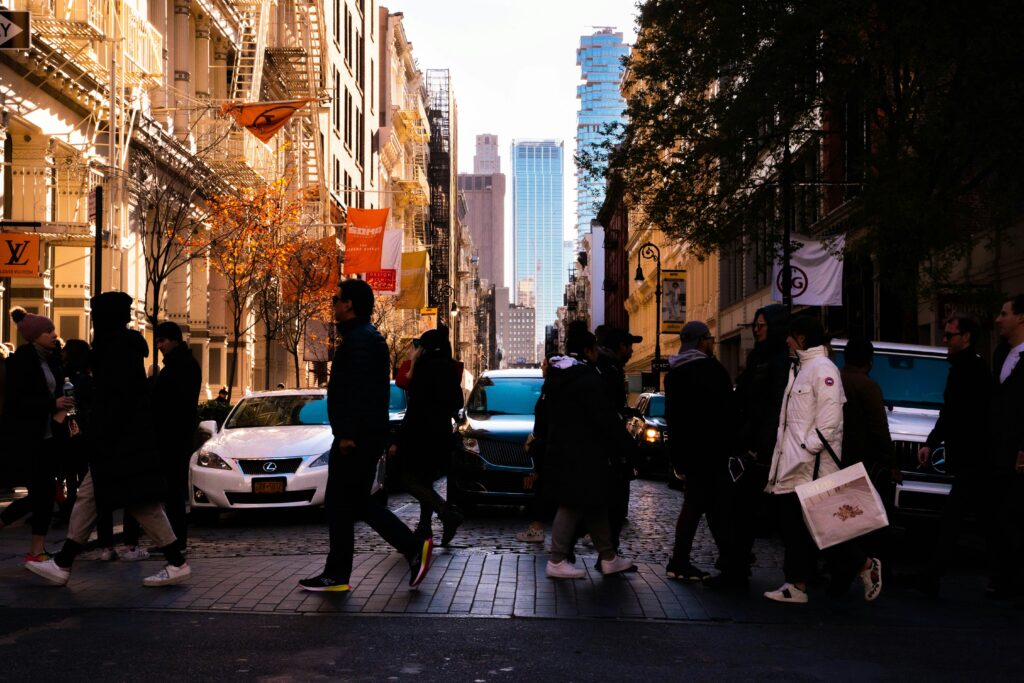 People walking on pavement by cars during daytime in NYC