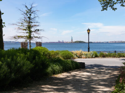 The Battery Park with a view of New York Harbor with the Statue of Liberty in New York City during Summer