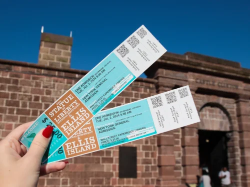 Hands holding admission tickets during Statue of Liberty and Ellis Island guided tour in NYC