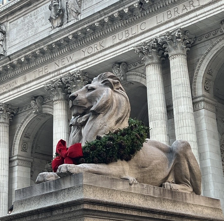Lion statue in front of the New York Public Library with holiday wreath