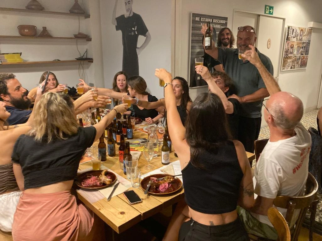 People cheering drinks at dining table in Mescladis