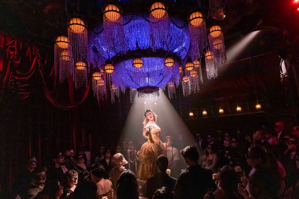 A singer beneath the chandelier at Masquerade in New York