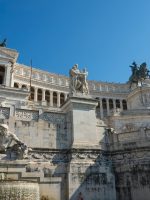 a large stone building with statues on top