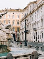 gray concrete statue in front of white concrete building during daytime
