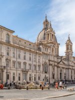 a large building with a dome and many windows with Piazza Navona in the background